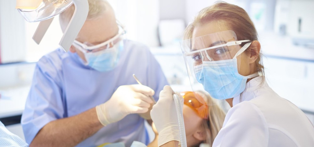 Zahnarzt und ZFA bei einer Behandlung