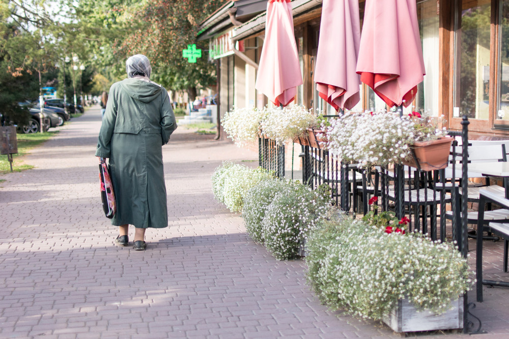 Ältere Frau läuft durch eine Fußgängerzone