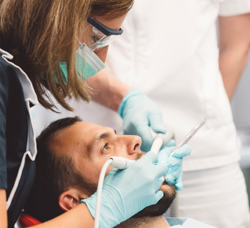 Zahnärztin untersucht Patient mit geöffnetem Mund