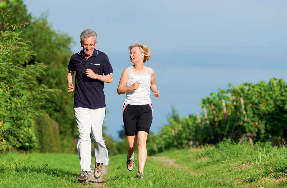 Älteres Paar joggt gemeinsam auf Feldweg