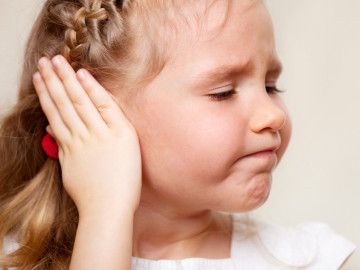 Kleines Mädchen hält sich das Ohr zu