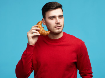 Nur ein Croissant am Ohr: Beim Essen sollte offenbar besser eine Smartphone-Pause eingelegt werden.