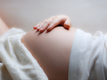 schwangere Frau mit Hand auf dem Bauch - soft