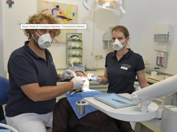Zahnarzt und ZFA mit passgenauen Masken bei der Arbeit