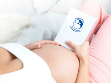 Schwangere Frau mit Mutterpass