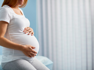 Hochschwangere legt Hände auf den Bauch