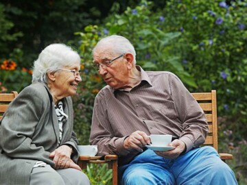 Altes Paar draußen beim Kaffee trinken
