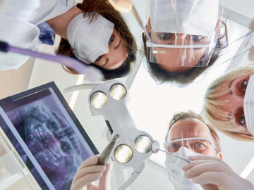 Aus Sicht des Patienten: Zahnarzt und drei Helferinnen schauen runter